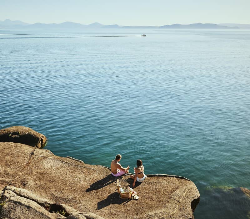 Couple having picnic at edge of Lake Taupo.
