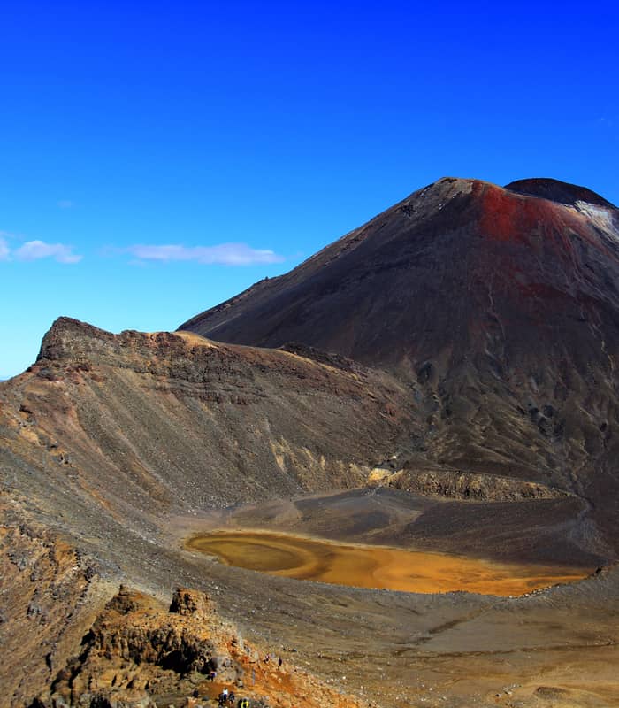Mt Ngauruhoe volcano with orange crater lake under a clear blue sky