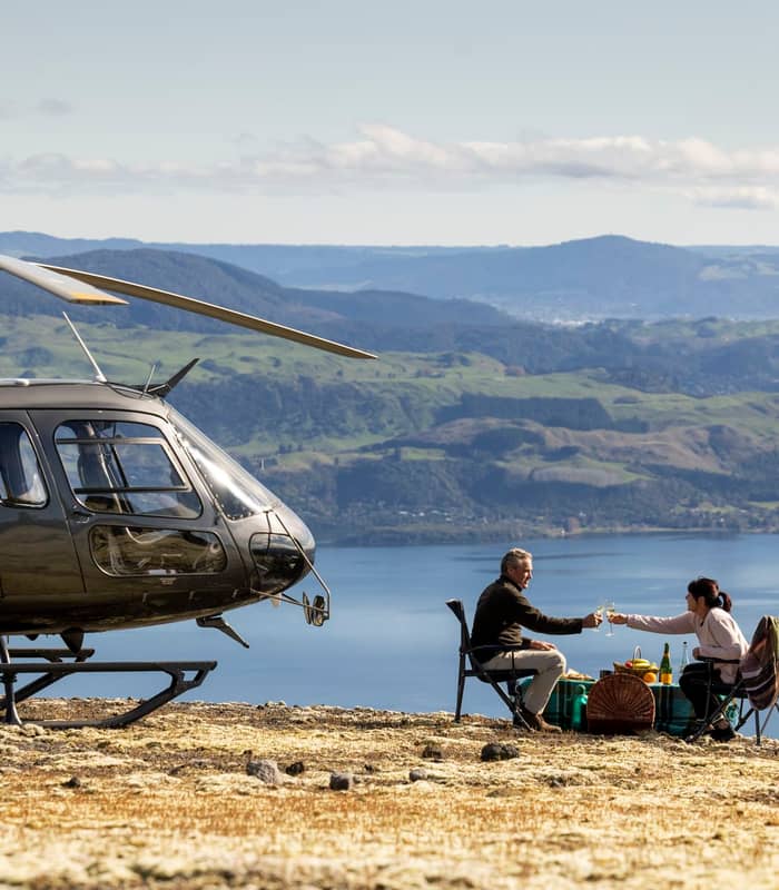 Couple having picnic ontop of mountain overlooking Lake Rotoiti with Volcanic Air.